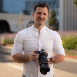 Cătălin Niță, fotograf, ținând un aparat foto